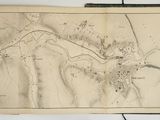 une vieille carte d'une ville posée sur une table, à côté d'un livre