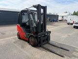 a red forklift truck parked in a parking lot