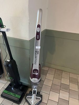 un aspirateur et une serpillière posés sur le sol d'une pièce