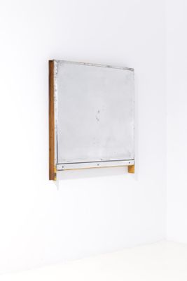 a mirror hanging on the wall in a white room