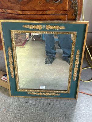 a mirror that is sitting on the floor in front of a dresser