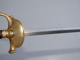 a gold and silver sword with a black handle