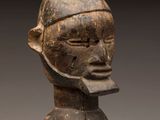a close up of a wooden statue of a person with a hat on