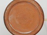 a brown plate with writing on it sitting on a table