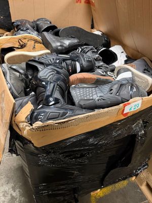 plusieurs paires de chaussures dans une boîte posée sur le sol