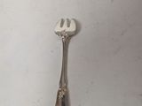 a silver spoon and a fork on a white surface