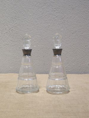 two clear glass bottles sitting on top of a table