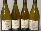 quatre bouteilles de vin sont alignées sur une table