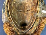 an image of a wooden mask on a blue surface