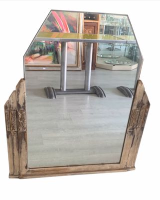a mirror that is sitting on the floor in front of a table