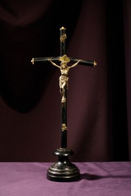 a crucifix on a table with a purple cloth