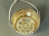 a silver bowl with a flower on it on a table