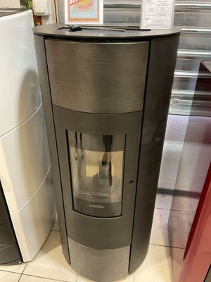 une cuisinière au milieu d'une pièce, avec un réfrigérateur derrière