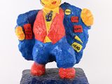 une figurine représentant un homme vêtu d'une veste bleue et d'un gilet rouge