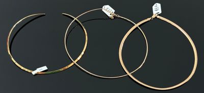 deux paires de boucles d'oreilles créoles en or sur fond noir