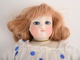 a close up of a doll with red hair and blue eyes