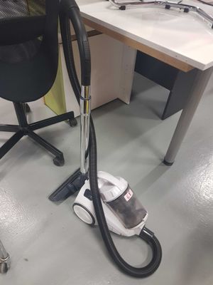 a vacuum that is sitting on the floor next to a chair