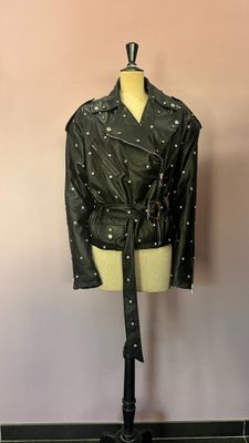 une veste en cuir noir cloutée posée sur un mannequin