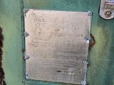 a metal plaque on the side of a green building
