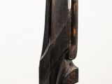a close up of a wooden sculpture on a white pedestal