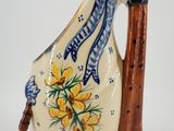 a small ceramic pitcher with a handle and flowers on it