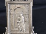 an image of a silver picture frame with a picture of a man holding a cross