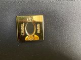 the handle of a black purse with a gold ring on it