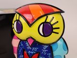 a colorful owl figurine sitting on a desk next to a computer