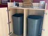 a picture of a kitchen with two trash cans in it