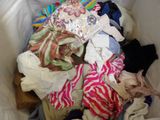 a pile of clothes in a white trash can