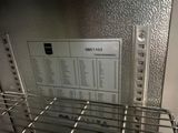 a metal rack with a menu on it in a kitchen