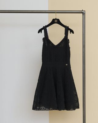 une robe noire suspendue à un portant dans une pièce