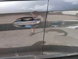 a reflection of a person in the door of a car