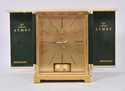a gold clock with a green cover on it