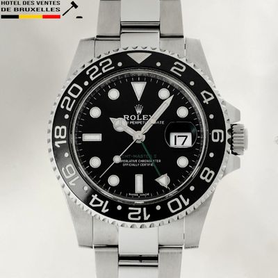 a rolex watch with a black dial on a stainless steel bracelet