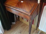 un petit bureau sur lequel est posée une lampe, dans une pièce