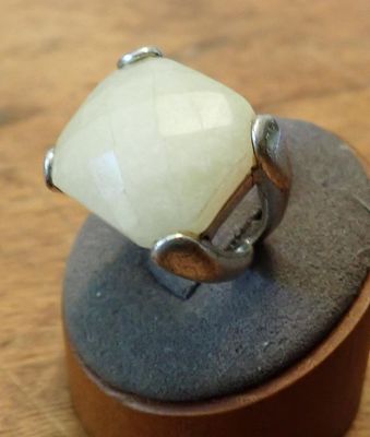 a ring with a white stone sitting on top of a rock