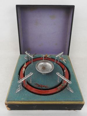 une assiette en argent dans une boîte ornée de libellules
