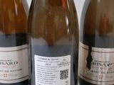 three bottles of wine are lined up on a table