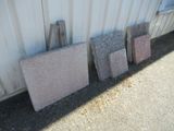 several pieces of granite are lined up against a building