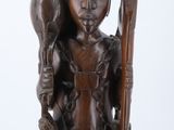 statue of a man holding a wooden stick and a bird on his shoulder