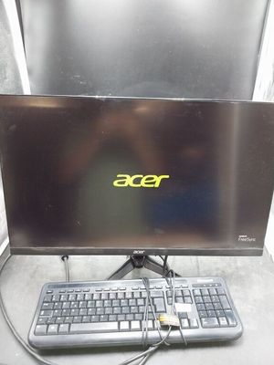 un écran d'ordinateur et un clavier posés sur un bureau