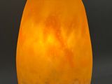 a yellow glass lamp hanging from a metal pole