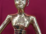 une statue en or représentant une femme les mains tendues