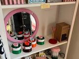 a white shelf with a mirror and various items on it