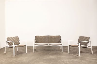 trois chaises et un canapé dans une pièce aux murs blancs
