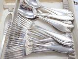 a tray with silverware in it on a table