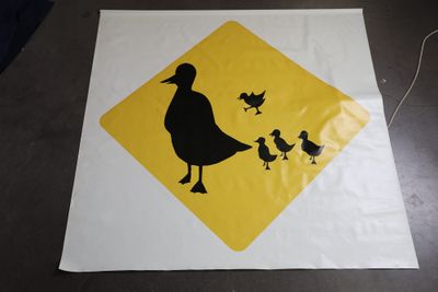 une affiche représentant un canard et ses canetons, posée sur une table