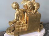 a gold statue of a boy and a bird on a bench