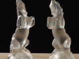 pair of clear glass sculptures of a horse and a dog on a table